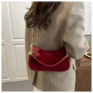 Détail du sac bandoulière en daim bordeaux avec pendentif cerise et logo FASHION & BAGS