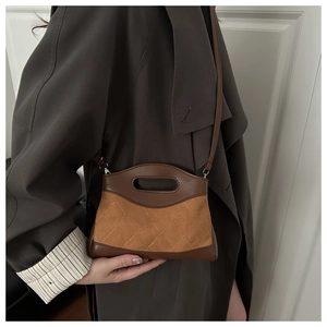 Detail of vintage patchwork crossbody bag featuring brown leather and quilted suede finish