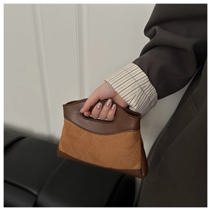 Detail of a quilted caramel fabric handbag with dark brown leather trim and oval handle