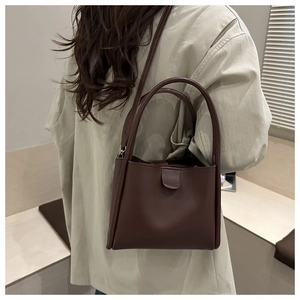 Deep brown bucket bag side view showing shoulder strap and smooth leather texture