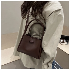 Detailansicht einer dunkelbraunen matten Bucket Bag aus Leder mit schmalem Schultergurt