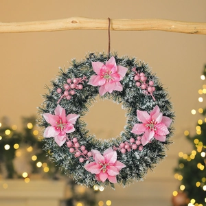 Christmas wreath with pink poinsettia flowers and white flocked pine needles