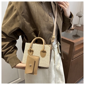 Détail d'un sac bandoulière en paille tissée avec sangle en cuir et pochette