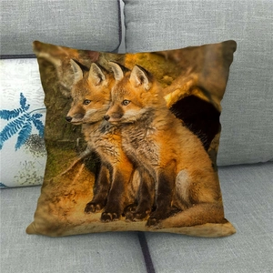 Close-up of linen cushion cover with realistic fox cubs print on a grey fabric sofa