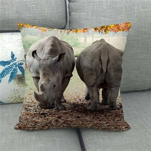 Detailed close-up of a linen rhinoceros wildlife pillow cover on a modern grey sofa
