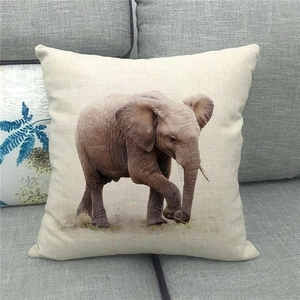 Detail of linen pillowcase with realistic African elephant print on a grey sofa