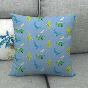 Detailed close-up of cartoon dinosaur linen pillow cover on a gray sofa