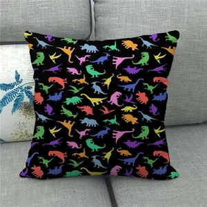 Close-up of square linen pillowcase with colorful dinosaur silhouettes on black background