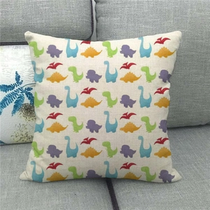 Close-up of linen cushion cover with colorful cartoon dinosaur prints on grey sofa