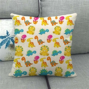 Close-up of a linen cushion cover featuring colorful cartoon dinosaur prints on a sofa