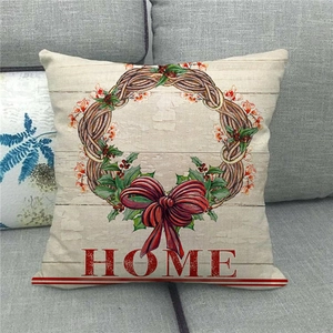 Close-up of linen cushion cover with Welcome Home wreath and red bow on sofa