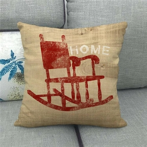 Detail of linen pillowcase featuring a red rocking chair and HOME text on grey sofa