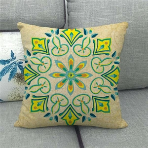 Détail de motifs mandala bohèmes sur une housse de coussin carrée en lin sur canapé