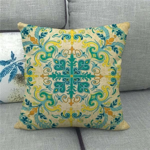 Détail du motif mandala bohème sur une housse de coussin en lin beige sur un canapé gris
