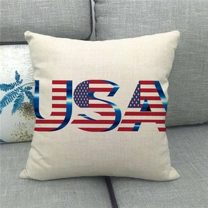 Close-up of linen pillowcase with USA flag letters on a modern grey fabric sofa