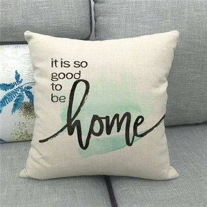 Detail of linen pillowcase featuring Sweet Home print on a grey fabric sofa
