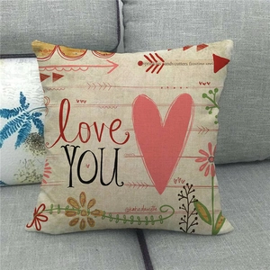 Linen Sweet Home decorative pillow cover with red heart and love YOU text on a grey sofa
