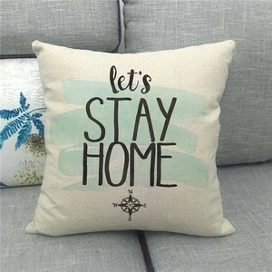 Detailed texture of linen pillowcase with Let's Stay Home text and compass design