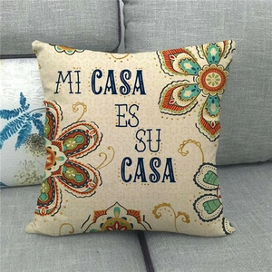Linen cushion cover with mandala floral pattern and Mi Casa Es Su Casa text on a grey sofa