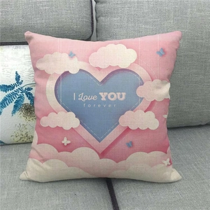 Détail d'une taie d'oreiller en lin avec motif cœur rose et texte I Love You sur canapé