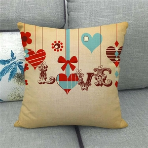Détail d'une taie d'oreiller en lin avec lettrage LOVE coloré et motifs de cœurs et fleurs