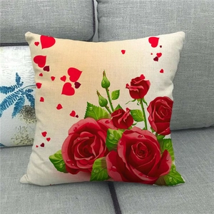 Gros plan de la housse de coussin en lin avec roses rouges et cœurs sur canapé