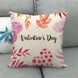 Close-up of Valentine's Day linen pillowcase with heart patterns on a grey sofa