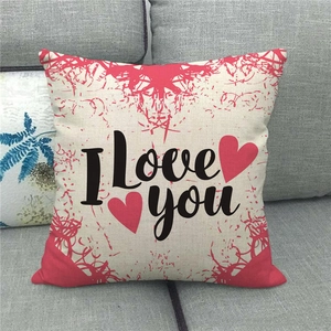 Détail de la housse de coussin en lin avec texte I Love You et coeurs rouges sur canapé