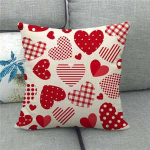 Linen blend throw pillow cover with red heart patterns on a gray fabric sofa