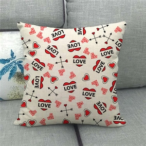 Detail of linen pillow cover with red heart and LOVE pattern on grey sofa