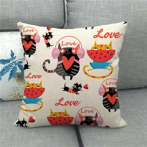 Detail of square linen pillowcase with cute cartoon cat prints on a grey fabric sofa