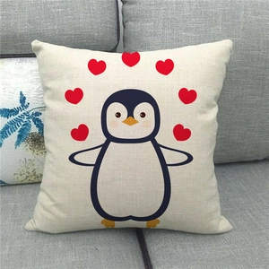 Linen pillowcase with cute cartoon penguin and red hearts on a gray sofa