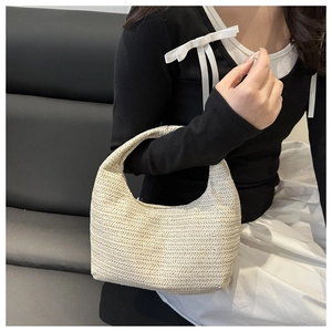 Vue détaillée d'un sac à main beige en paille tressée avec une texture ondulée élégante