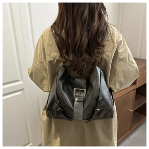 Detail of dark gray vintage backpack with large metal buckle and adjustable straps