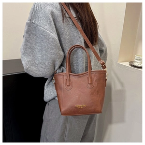 Détail du sac cabas vintage marron avec logo doré et bandoulière réglable pratique