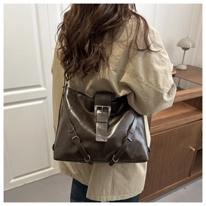 Detail view of large dark brown retro leather backpack with metal buckle on a model