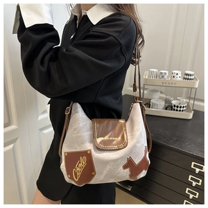 Side view of a vintage tote bag featuring grey canvas and brown leather patch details