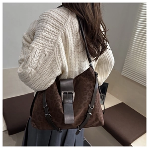 Detail of dark brown leopard print suede tote bag with vintage metal buckle and side strap