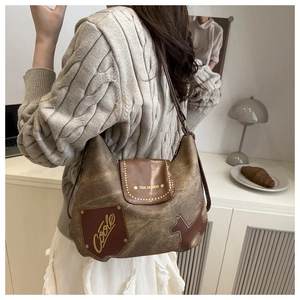Detail of vintage brown faux leather tote with unique dog silhouette and gold stud accents