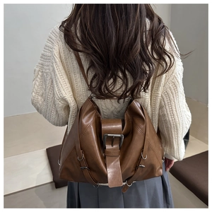Brown vintage PU leather backpack worn by model with adjustable straps and buckles