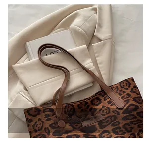 Detail der Leopard-Tragetasche mit braunem Lederetikett und robusten Trageriemen