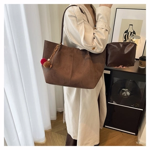 Dettaglio della borsa shopper in finto camoscio marrone con pochette e ciondolo in pelliccia