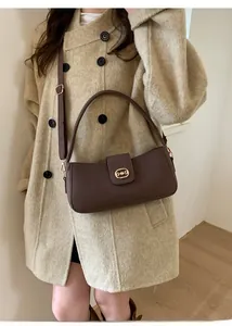 Detail of dark brown baguette underarm bag with vintage golden metal buckle closure