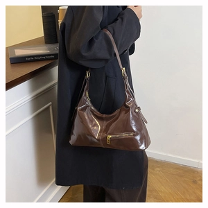 Detailansicht der glänzenden tiefbraunen Hobo-Tasche aus Leder mit Metallreißverschluss