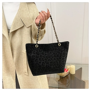 Detail of grey leopard print tote bag with gold chain and leather braided shoulder strap
