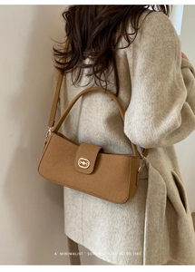 Retro brown crossbody bag with gold buckle detail worn with beige wool coat