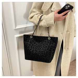 Detail of leopard print tote bag with gold chain strap on beige wool coat