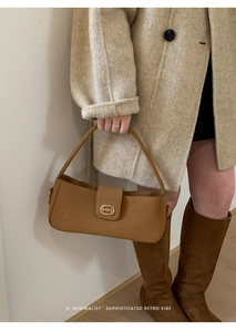 Detail view of brown matte leather baguette bag with minimalist golden metal buckle