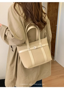 Minimalist beige tote bag featuring silver buckle detail shown on shoulder for daily style