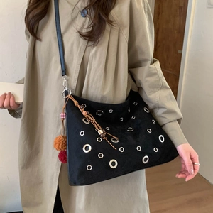 Borsa a secchiello da donna in pelle scamosciata nera con borchie e ciondolo colorato